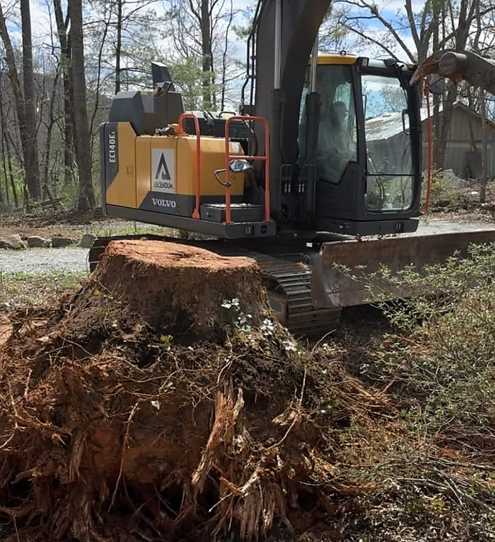 Excavator working a stump and root pile