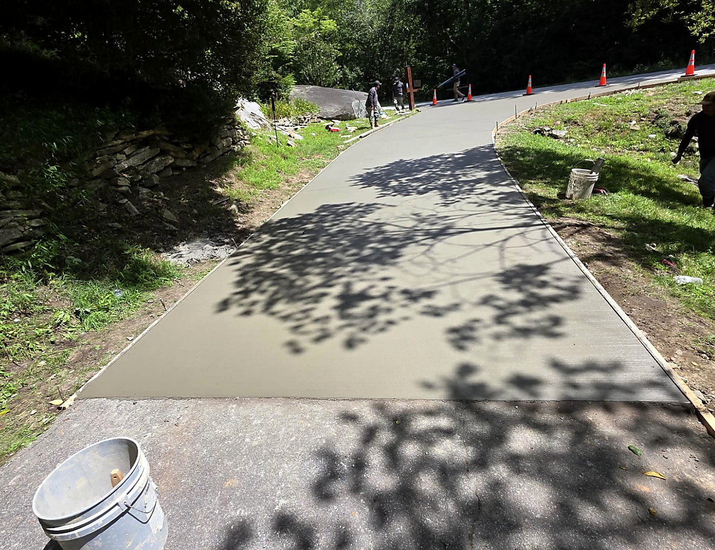 Freshly poured concrete driveway curving up to a house