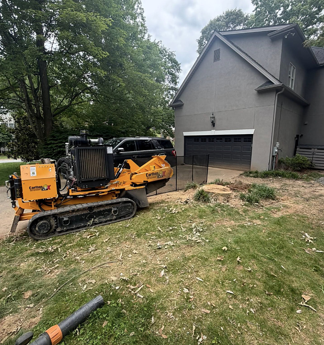 Grinder alongside a garage on a tight residential lot
