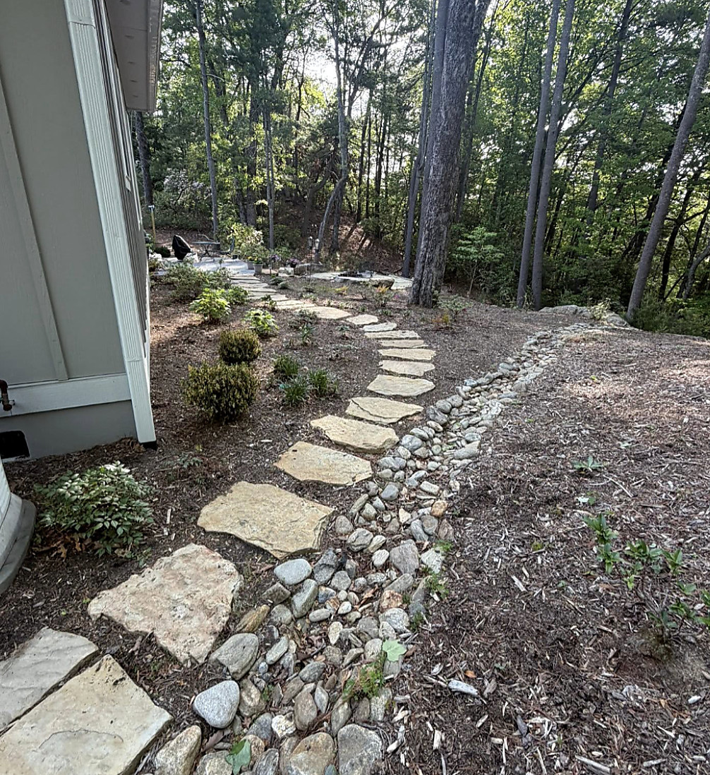 River-rock border and stone walk beside a house
