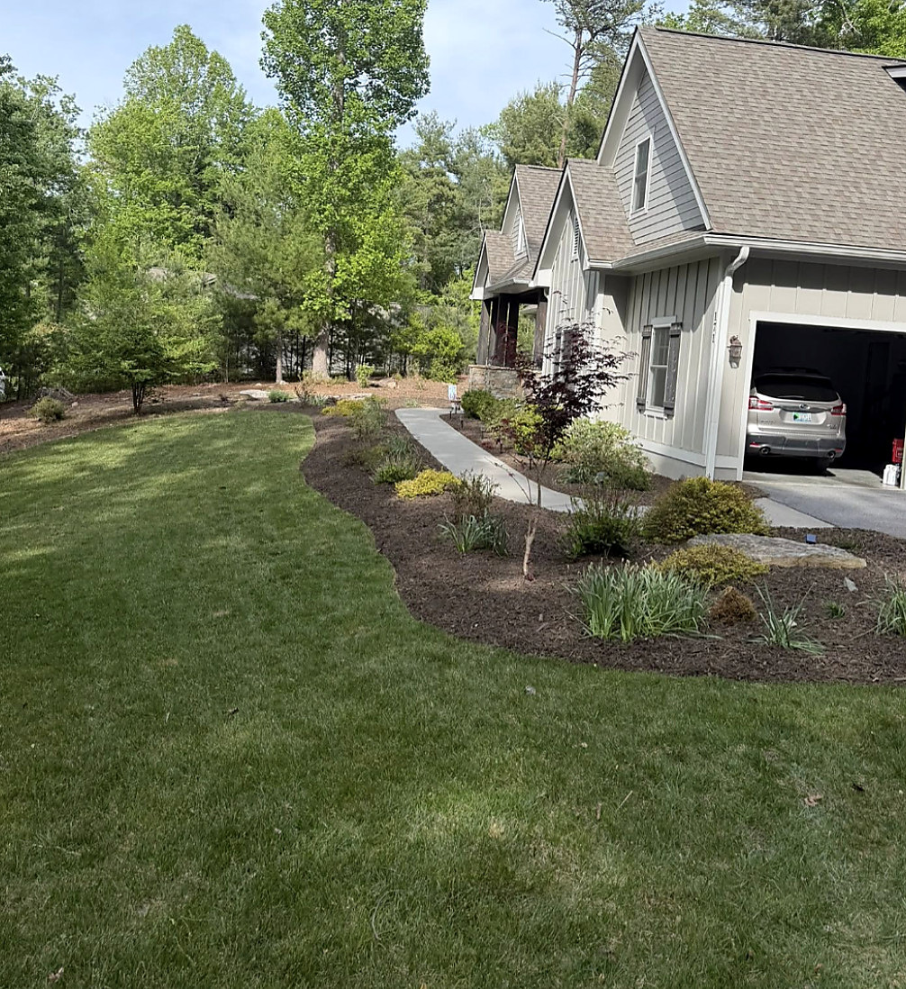 Finished lawn and mulched beds in front of a house