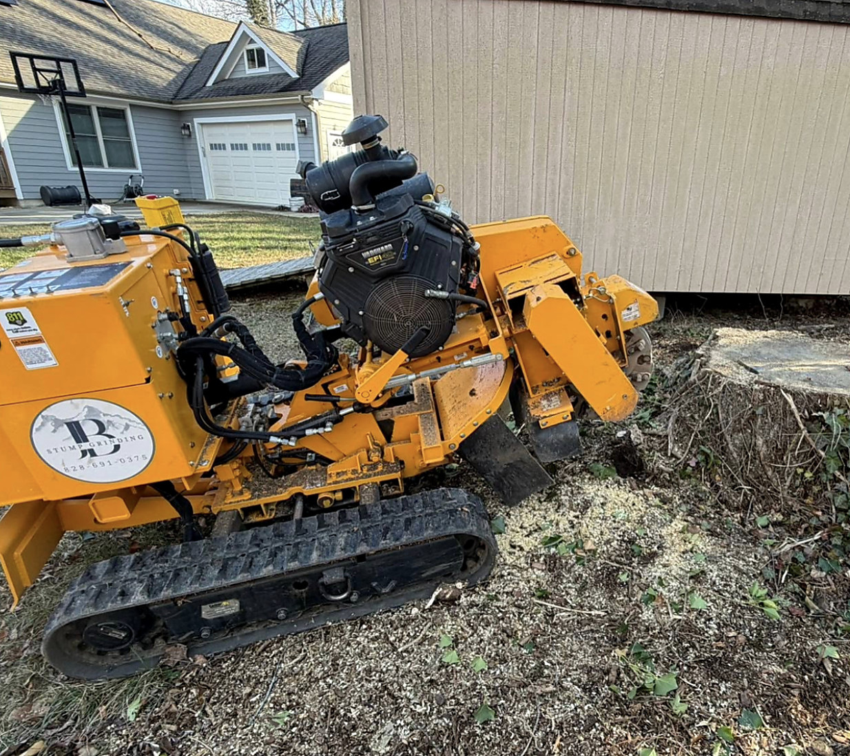 Carlton grinder positioned between a house and an outbuilding