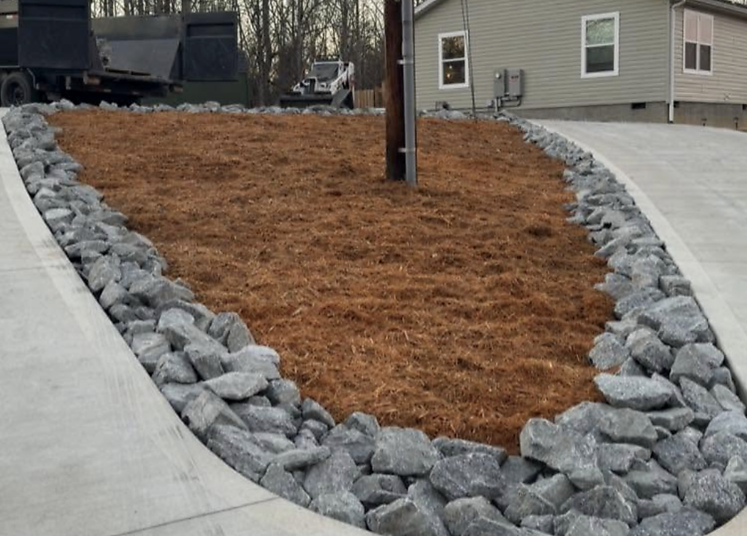 Fresh mulch bed and boulder edging beside a walkway