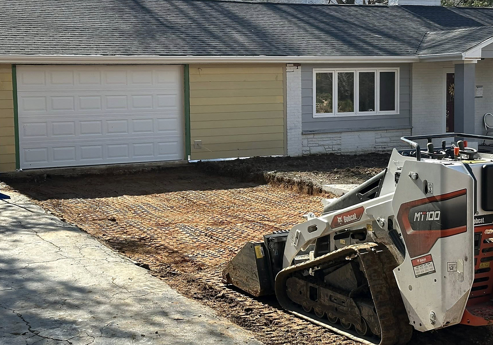 Graded pad and new base beside a garage